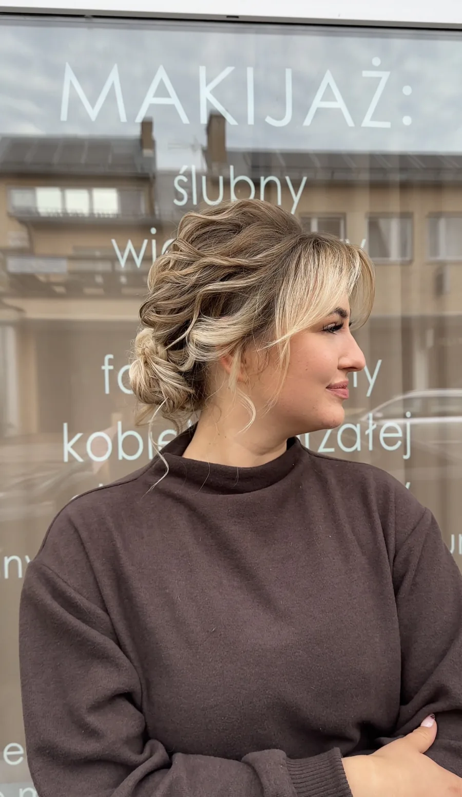 Profil klientki z miękkim upięciem i białą kwiatową ozdobą.